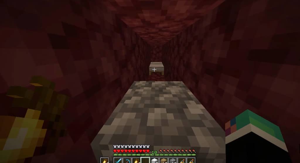 Image showing a bed set up in the Nether Biome behind a cobblestone block.